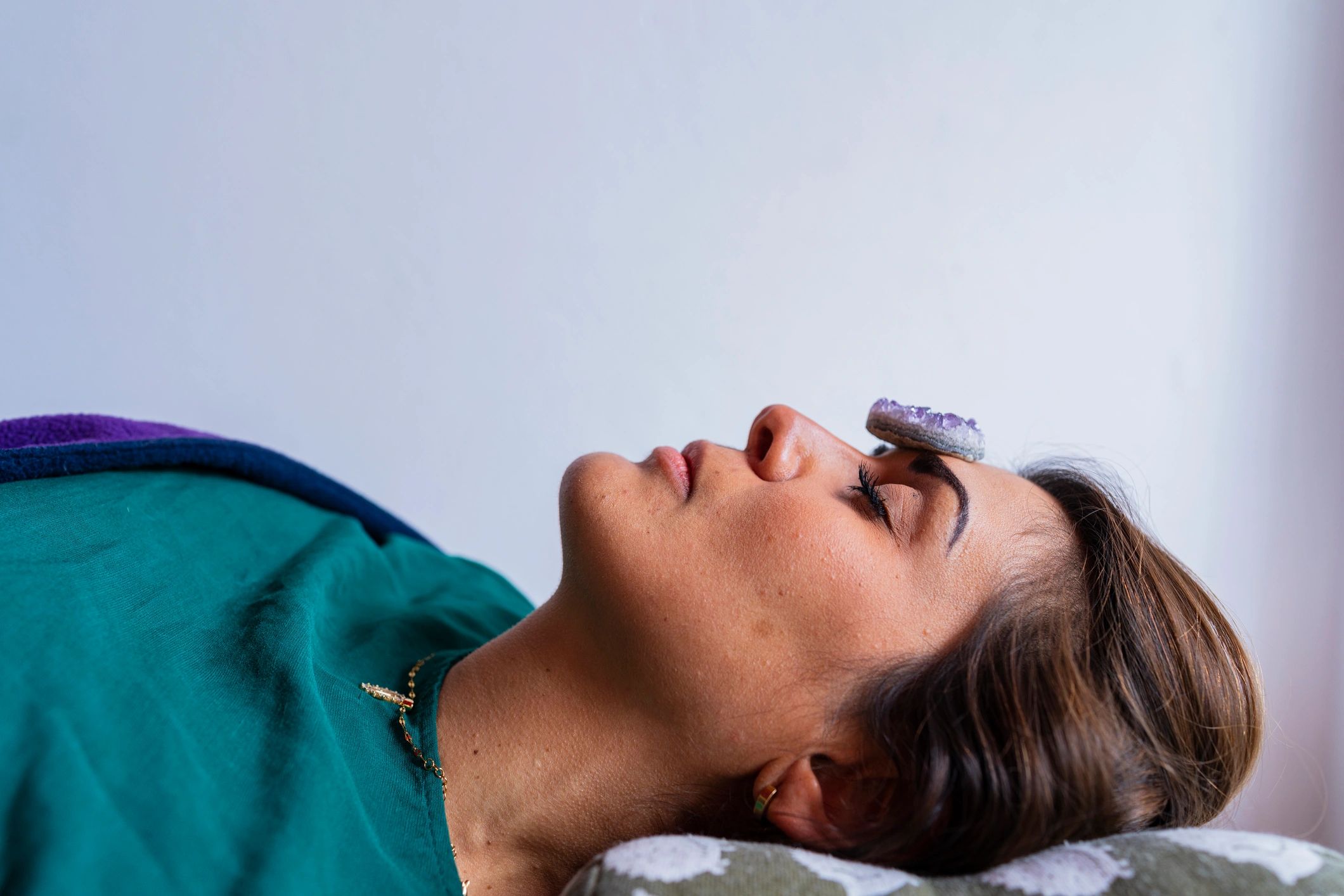 Client receiving meditation therapy with crystals placed on the body