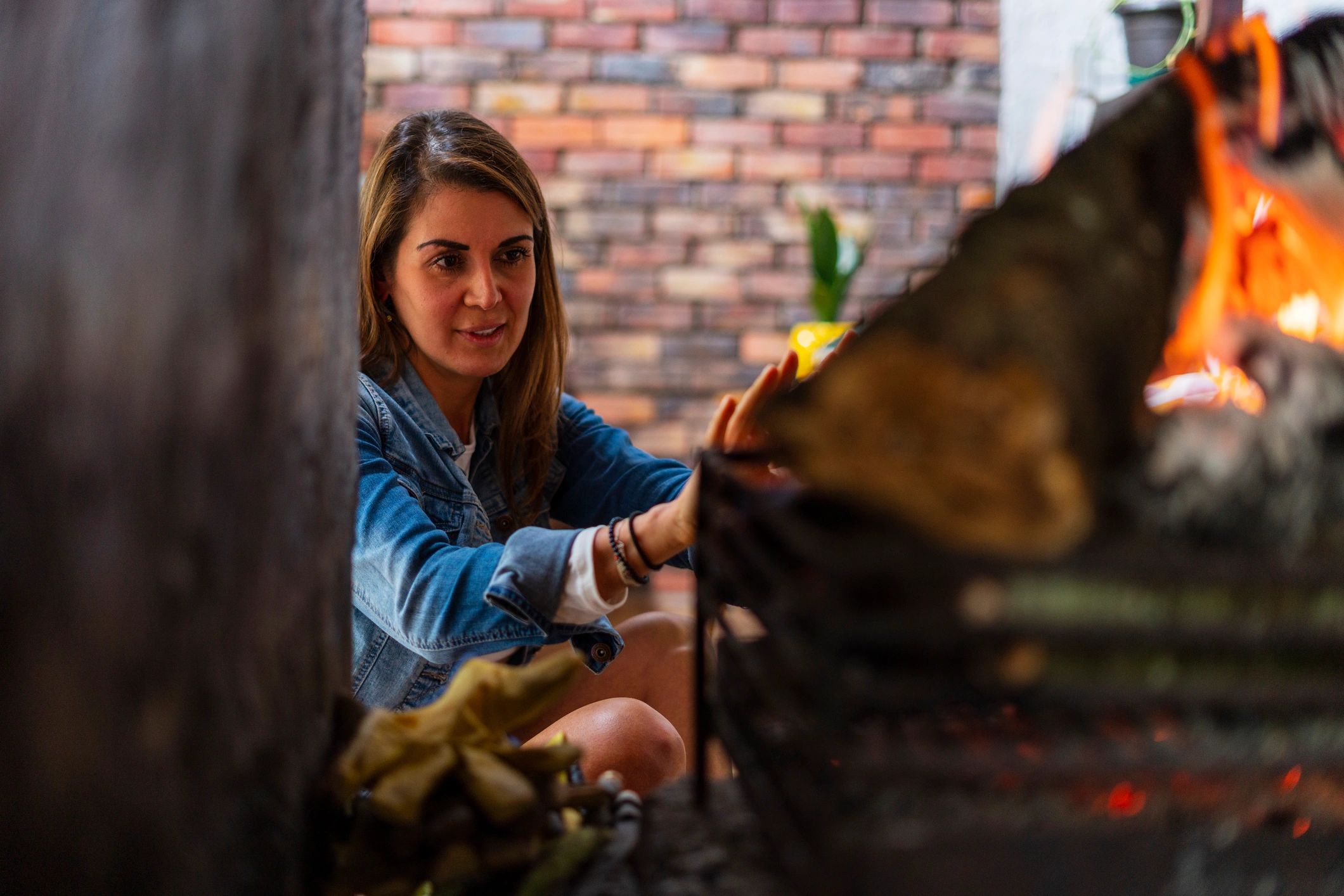 Woman sitting on the floor by a fireplace enjoying a moment of calm